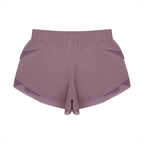 Purple paneled yoga shorts with wide elastic waistband and layered hem detail.