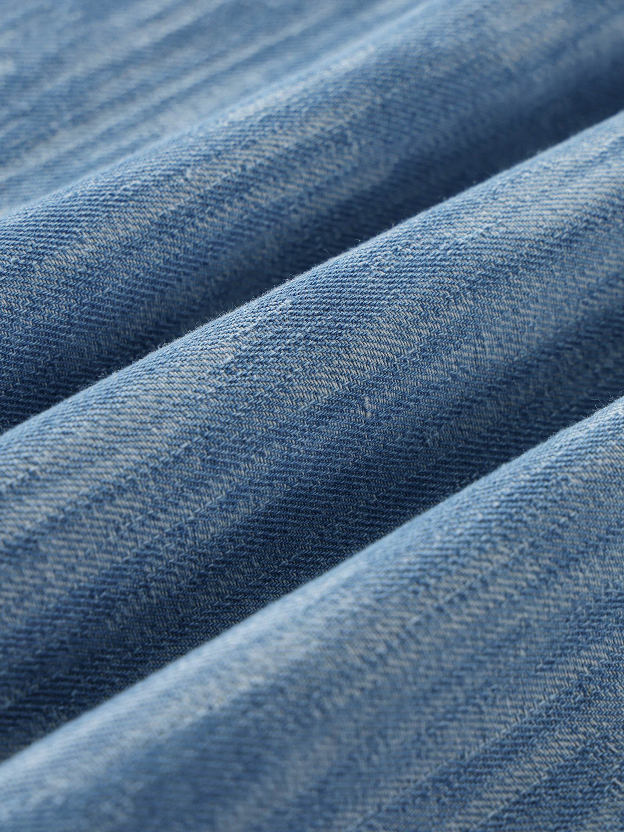 Distressed blue shirt fabric texture and close seam detail