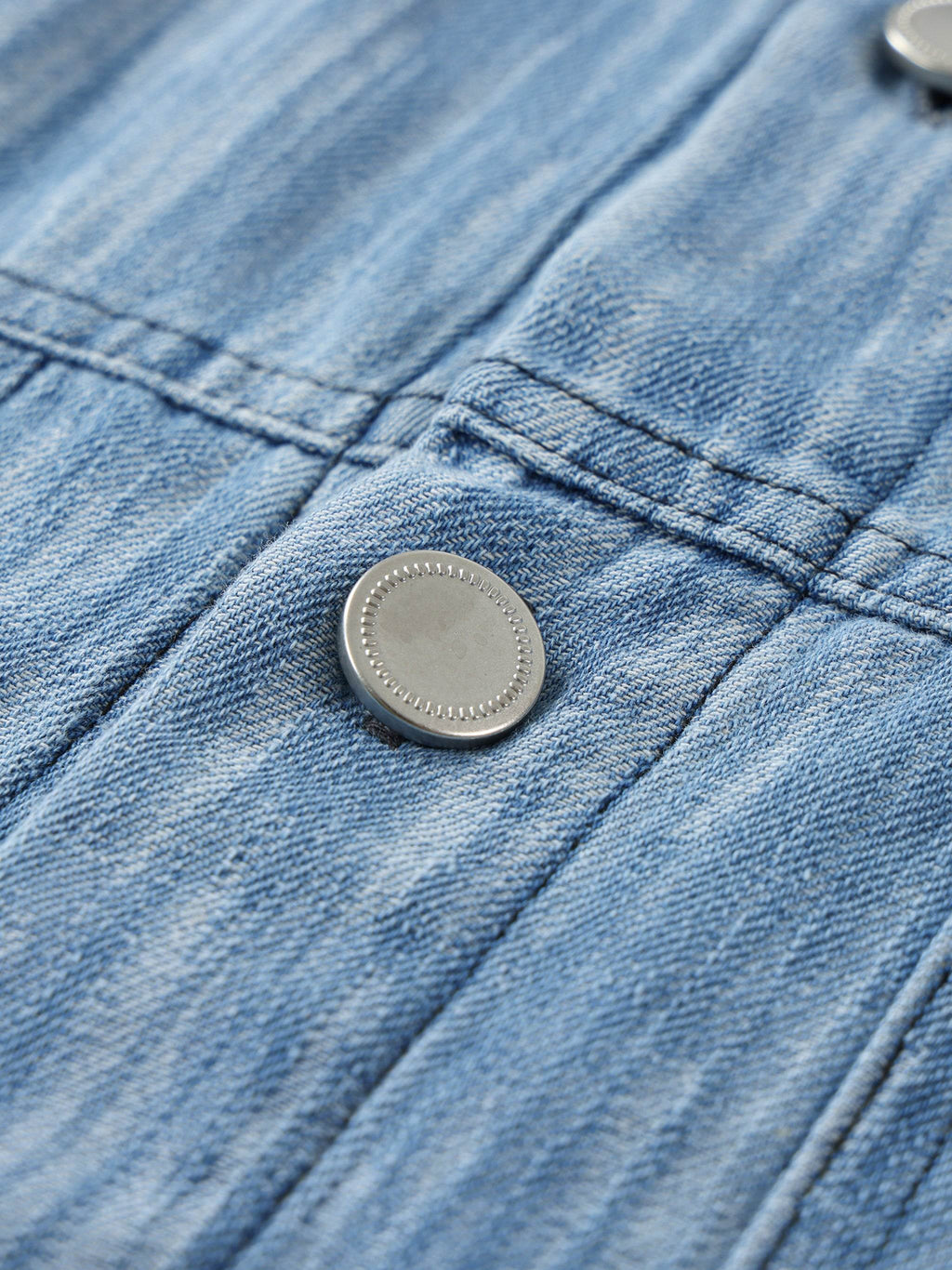 Distressed blue shirt chest button detail with stitched placket