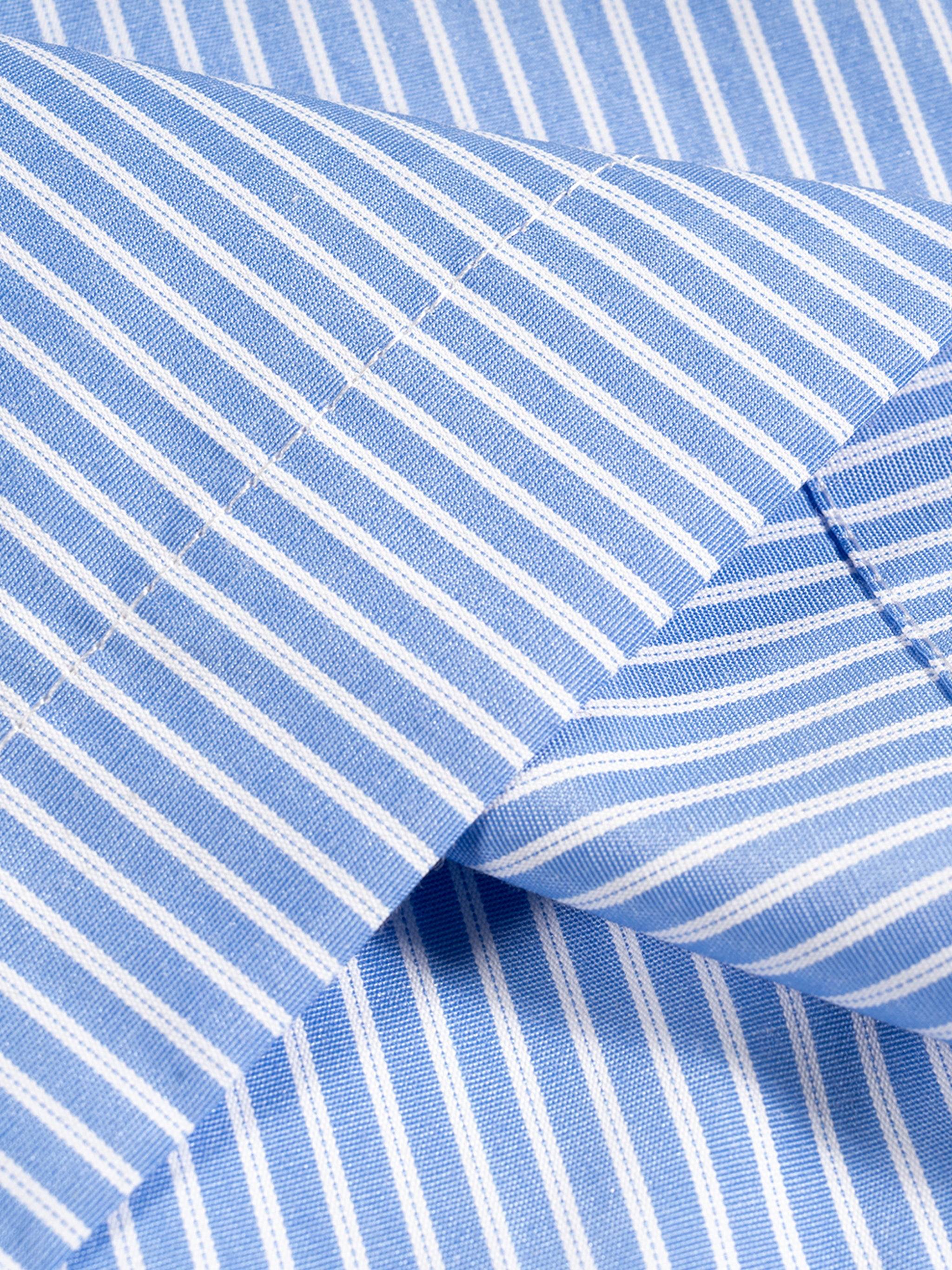 Blue-and-white vertical stripe shirt fabric close-up with curved seam