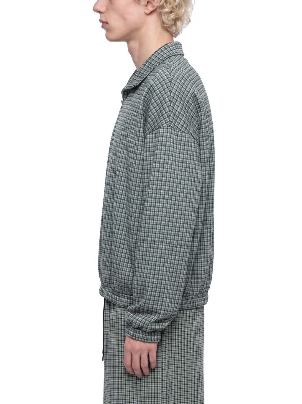 Mens plaid quarter-zip sweatshirt in dark green, worn side view, model torso
