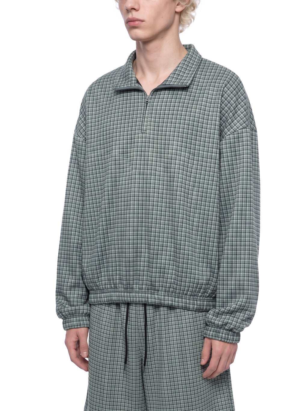 Green plaid quarter-zip sweatshirt with collared neckline and long elastic cuffs