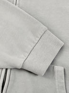 Light gray hoodie sleeve with ribbed cuff and exposed zipper tape detail