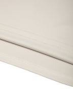 Lower hem seam detail on light beige color-block performance T-shirt