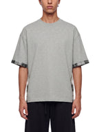 Gray unisex T-shirt on model, plaid paneled sleeves and side hem panels