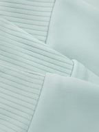 Mint green crop tank top fabric close-up with fine ribbed knit and seam stitching.