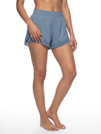 Women’s blue paneled yoga shorts shown in motion with elastic waistband
