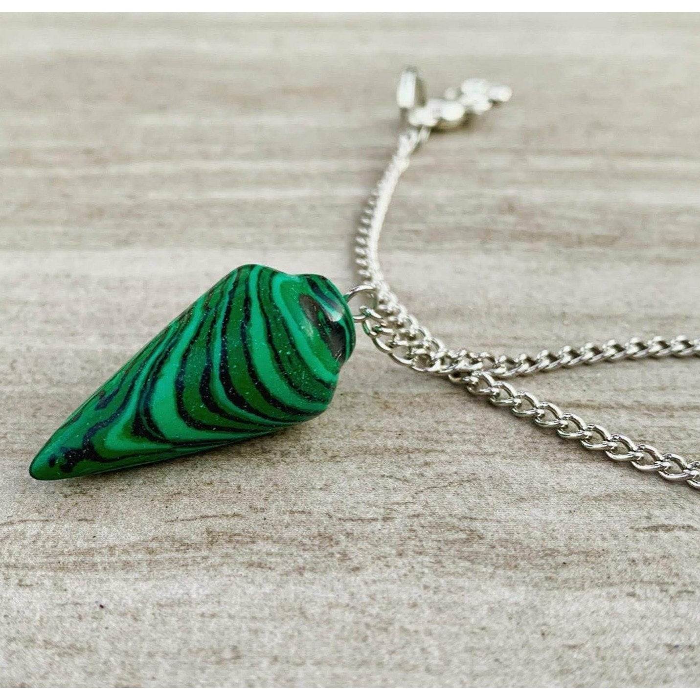 Malachite pendulum with green striped stone and silver chain, loop bail visible