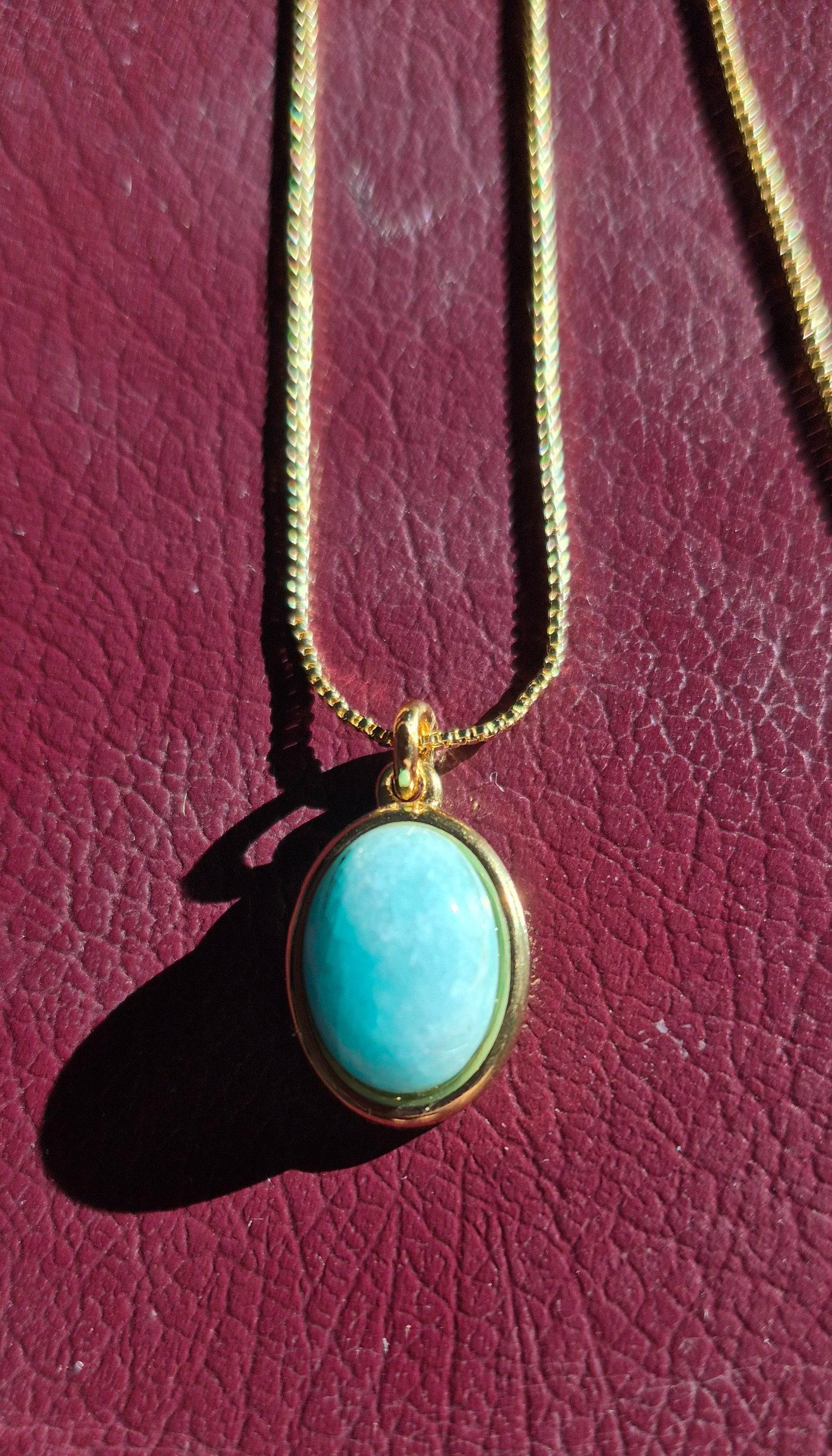 Gold-tone oval pendant necklace with single turquoise-blue oval stone on chain