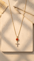 Gold-tone cross necklace with orange round gemstone and white stone details