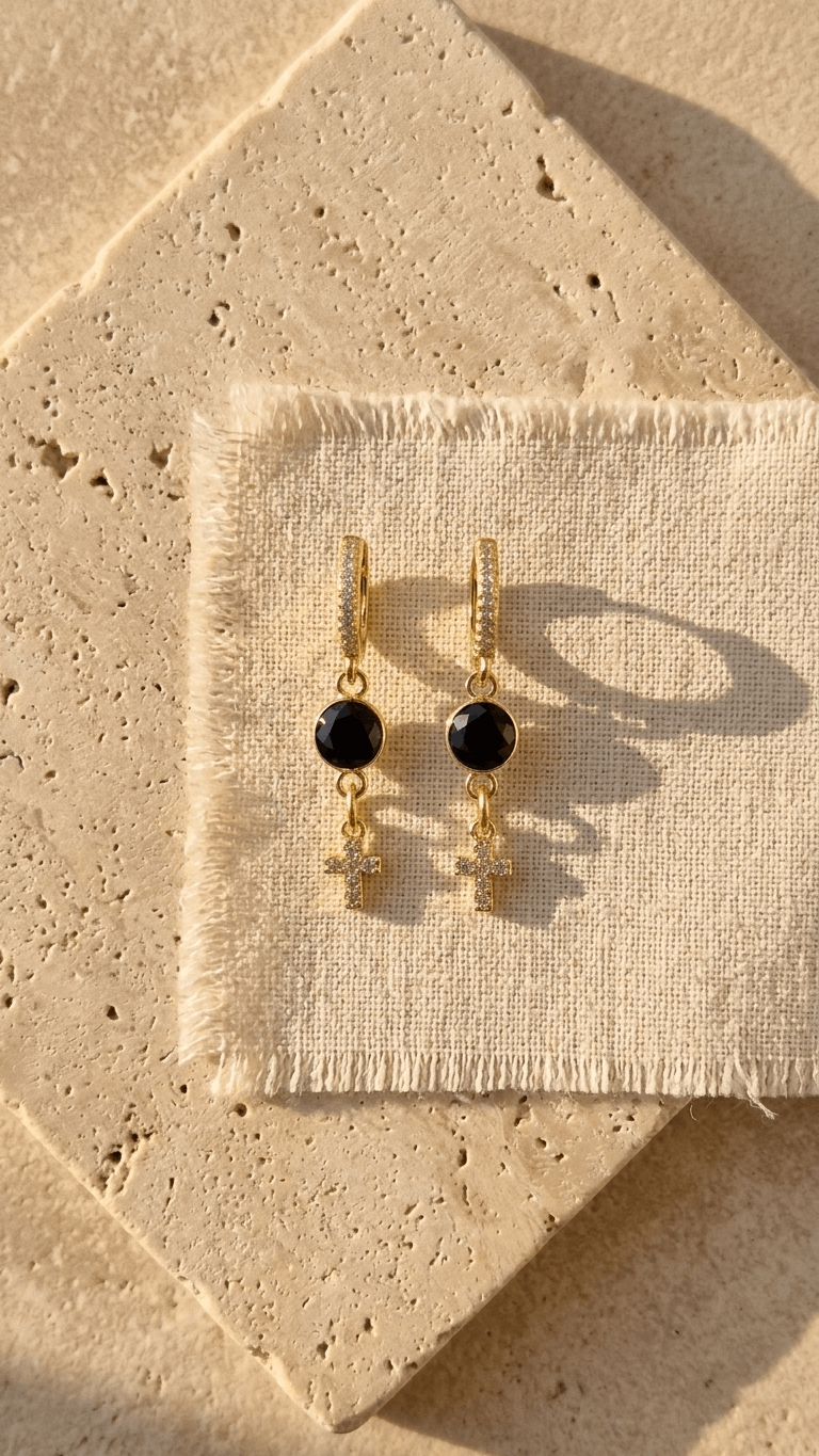 Gold-tone huggie earrings with black zircon rounds and white zircon cross dangles