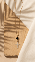 Black and white zircon cross pendant necklace on a gold chain