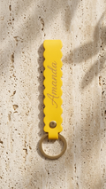 Yellow scallop-edge leatherette keychain with round key ring and engraved script