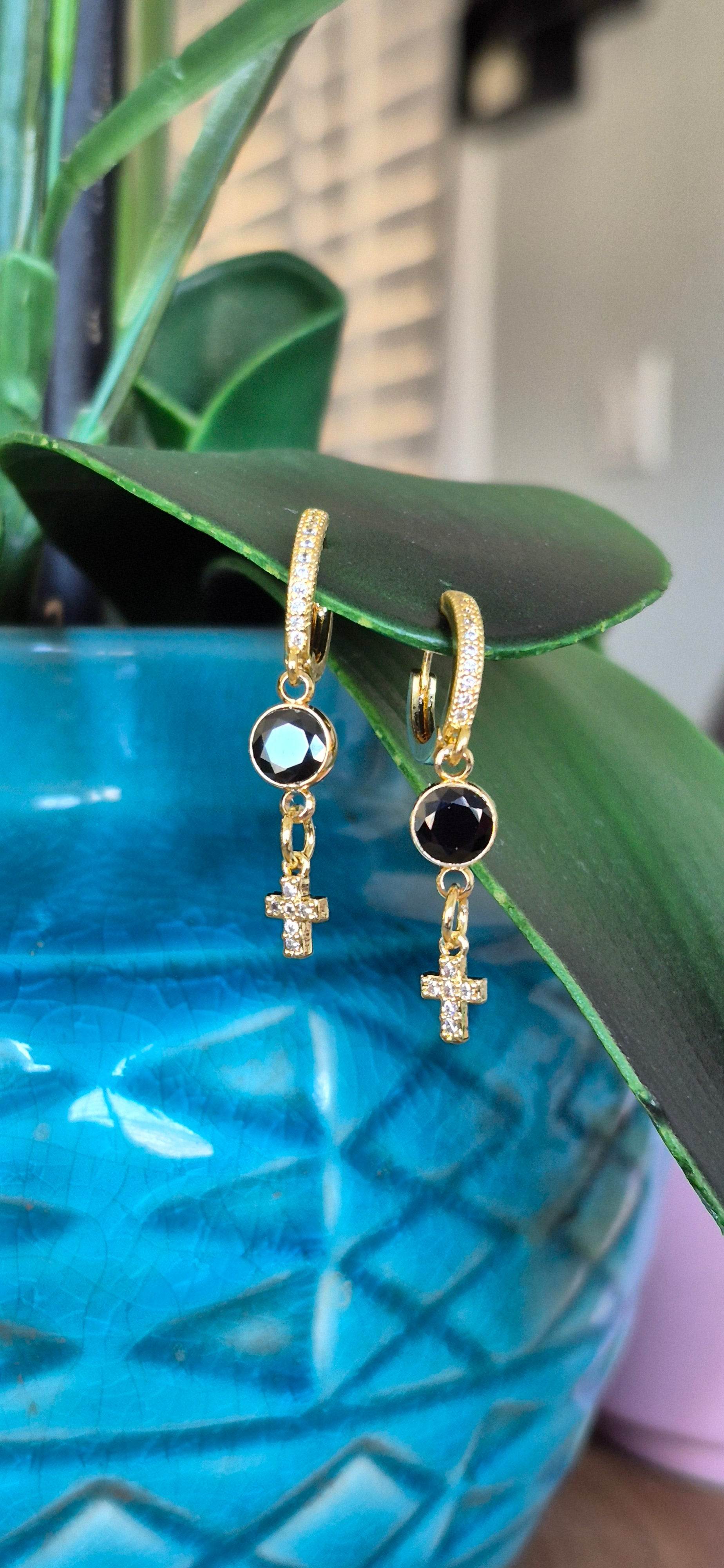 Gold hoop huggie earrings with black round zircon, gold chain, and cross dangle