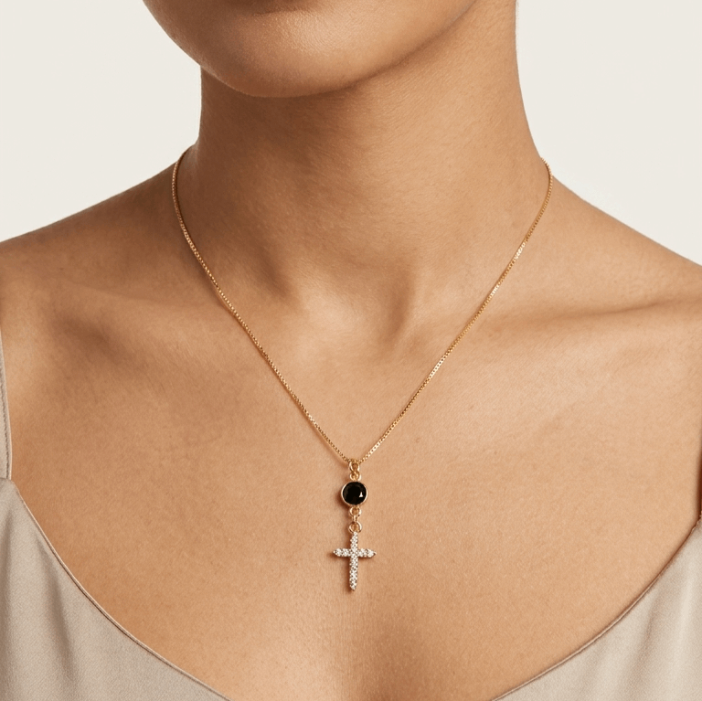 Gold-tone cross necklace with white zircon stones and small black accent pendant