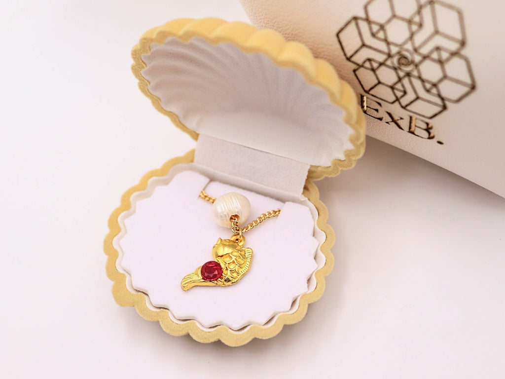 Gold pearl choker necklace with gold sea-animal pendant and red gemstone