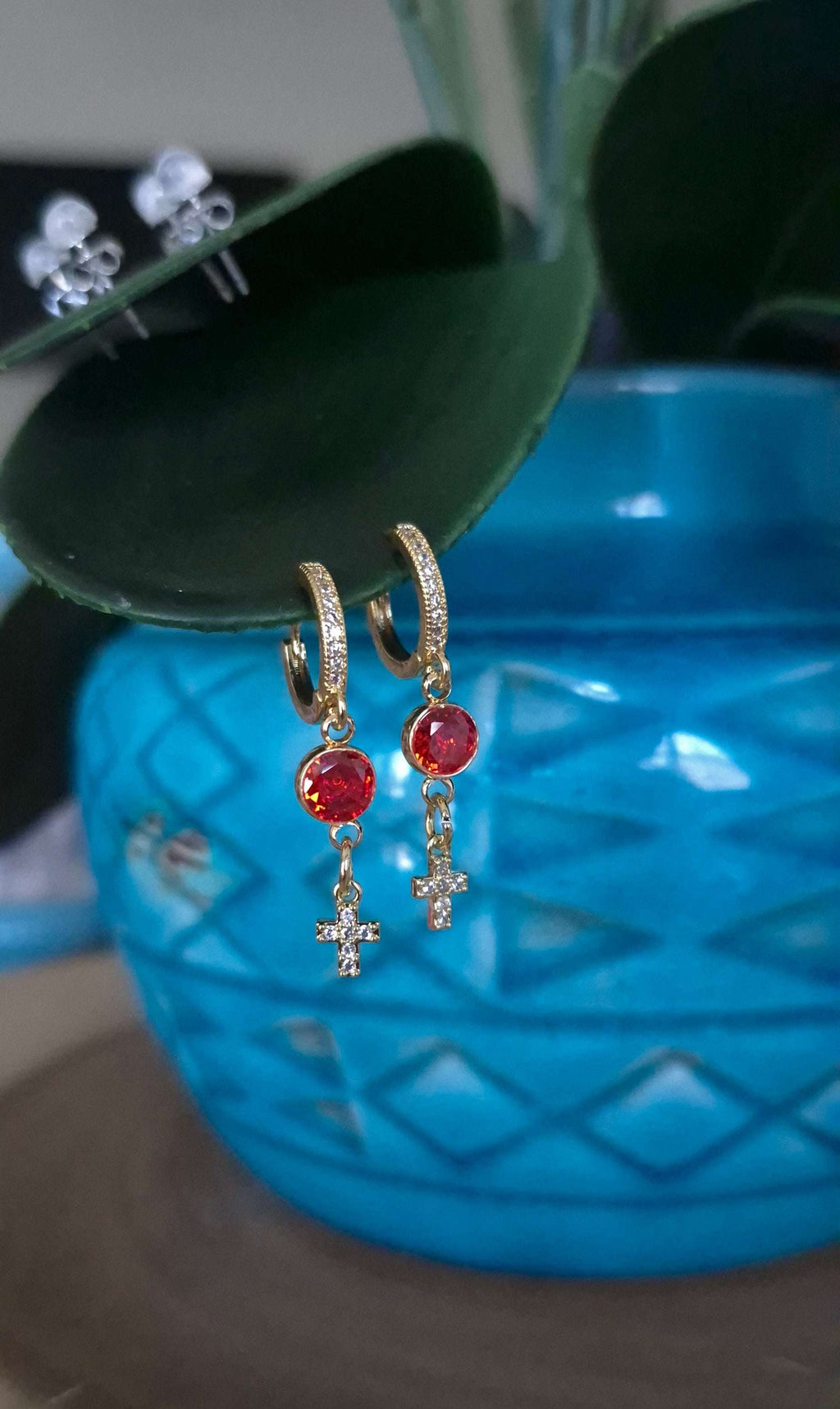 Gold-tone cross dangle earrings with orange and red gemstone drops and small hoops