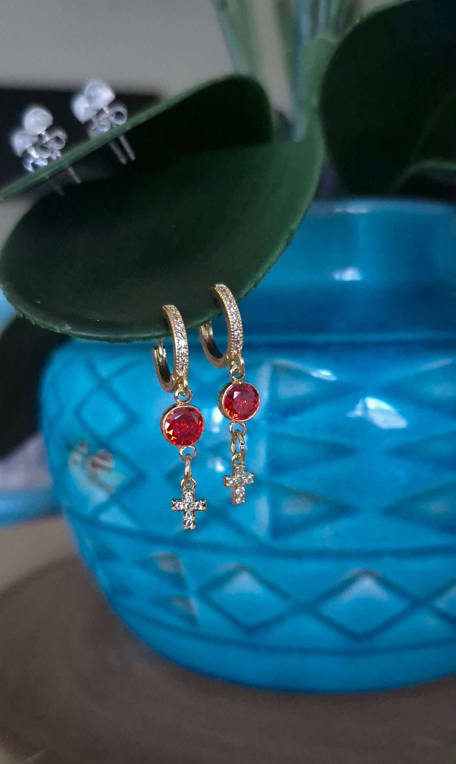 Gold-tone cross dangle earrings with orange and red gemstone drops and small hoops