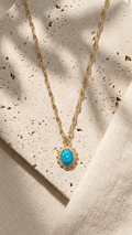 Blue opal pendant necklace with gold-tone chain and oval cabochon